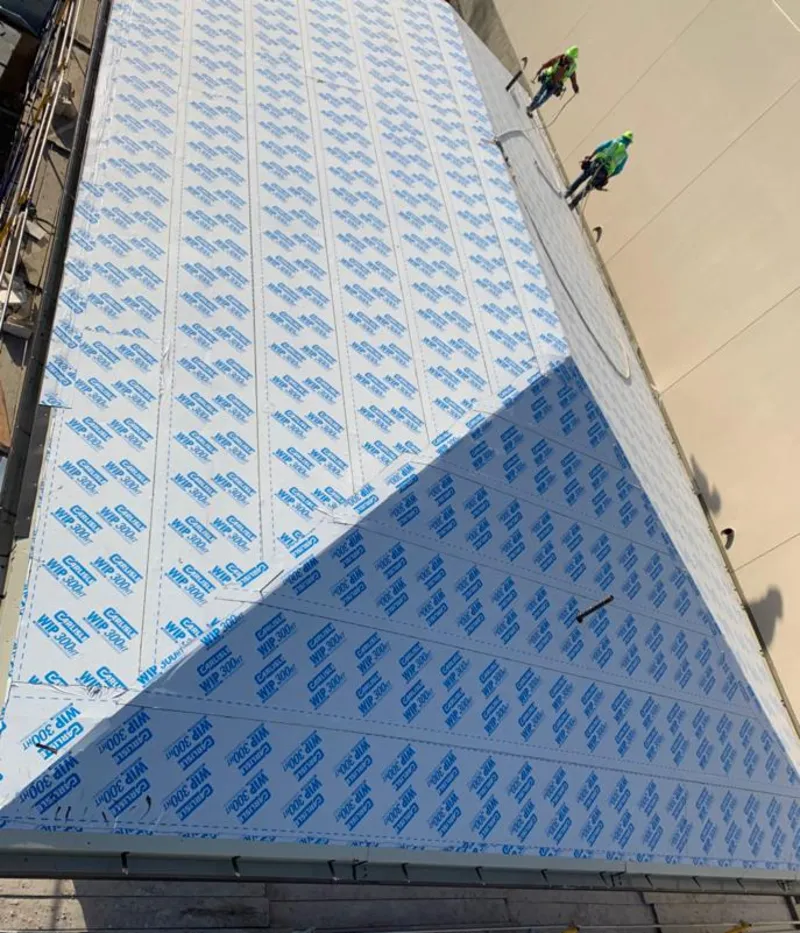 Professional roofers installing underlayment on a metal roof in Stokesdale